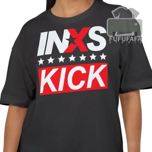 May include: Black t-shirt with the band name INXS in white letters, with a red star and a red rectangle with the word KICK in white. Seven white stars are above the red rectangle.