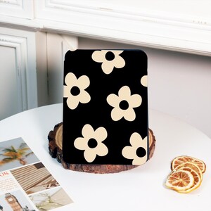 May include: Black e-reader case with a white daisy pattern.