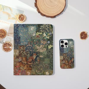 May include: A patterned notebook and phone case featuring a fox illustration. The design incorporates floral and geometric elements in shades of green, blue, and brown. The notebook is rectangular, and the phone case is a rectangle with rounded corners.