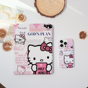 May include: A pink and white phone case and tablet case with a Hello Kitty design. The cases feature the text "trust God GOD'S PLAN" and "HOLY BIBLE". The tablet case shows a large Hello Kitty holding a book.