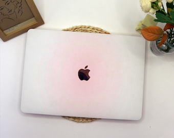 May include: A white laptop computer with a silver Apple logo on the lid. The laptop is sitting on a woven straw coaster.