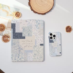 May include: A matching set of a tablet case and a phone case. Both cases feature a patchwork design in shades of blue and white with floral patterns. The tablet case has the text "may Jesus be seen in me in spite of me."