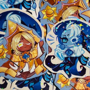May include: A selection of vibrant stickers showcasing cartoon characters. One sticker depicts a character with blonde hair and a golden outfit, the other a blue character. Both have star and sun designs.