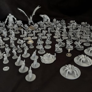 May include: A collection of gray plastic miniature figures, including a dragon, a spider, and various humanoids, arranged on a black surface.