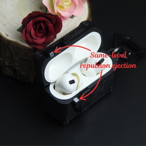 May include: Black protective case for wireless earbuds, open to reveal white earbuds. The case has the name "Jaden" engraved on it. The text "Same-level repulsion ejection" is also visible.