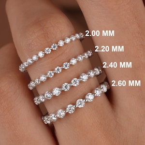 May include: Four silver eternity bands with diamonds, each band is labeled with its width in millimeters: 2.00 MM, 2.20 MM, 2.40 MM, and 2.60 MM.