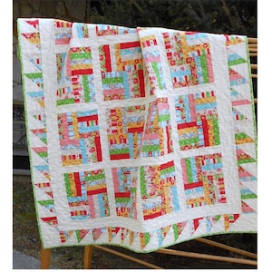 May include: A colourful quilt pattern called "Chutes & Ladders" with a white background and a variety of red, green, blue, and yellow fabrics. The quilt is made with a "Delighted" fabric line by The Quilted Fish for Riley Blake. The quilt is available in sizes from crib to queen/king.