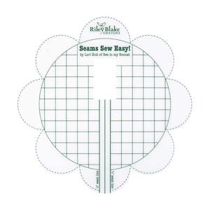 May include: A white sewing template with a grid pattern and a flower shape. The template is labeled "Seams Sew Easy!" by Lori Holt of Bee in my Bonnet. It has two lines labeled "1/4" seam line".