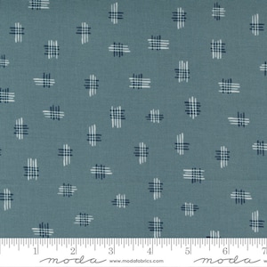 May include: A blue fabric with a white and dark blue checkered pattern. The fabric is measured in inches with the text "moda" printed on the ruler.
