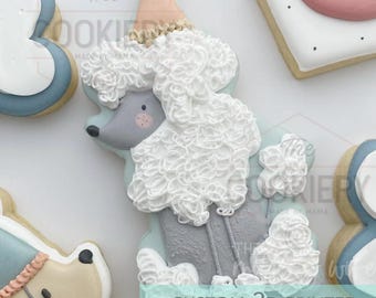 May include: A decorated cookie in the shape of a poodle wearing a party hat. The poodle is white with gray accents and a pink nose. The cookie is surrounded by other decorated cookies. The text "CUSTOM 3D PRINTED COOKIE CUTTER" is visible.