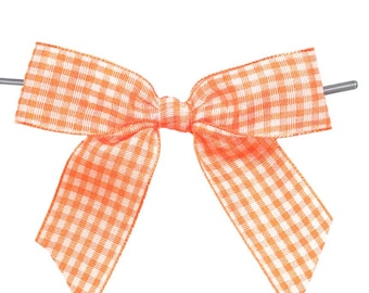 May include: An orange and white gingham bow with metal rods on each side. The bow is centered on a white background. The text "WITH ❤️ BY Designer Cookies" is printed below the bow.