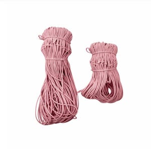 May include: Two bundles of pink cord, tightly wrapped at the top and cascading downwards. The cord appears to be made of a flexible material, and the bundles are of different sizes. The background is plain white.