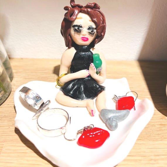 A handmade clay "drunk girl" trinket tray that's equal parts functional jewelry organizer and cheeky desk accessory your friend will show everyone.