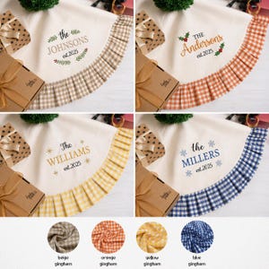 May include: A set of four personalized Christmas tree skirts. Each skirt features a different family name and the year 2025 embroidered on a cream-colored fabric. The skirts have a ruffled gingham border in beige, orange, yellow, and blue.