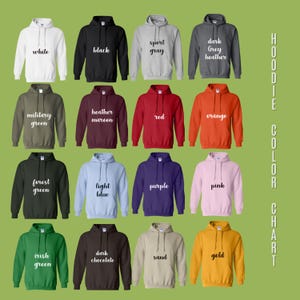 May include: A color chart of hooded sweatshirts in various colors, including white, black, sport gray, dark grey heather, military green, heather maroon, red, orange, forest green, light blue, purple, pink, irish green, dark chocolate, sand, and gold. The text "HOODIE COLOR CHART" is on the right.