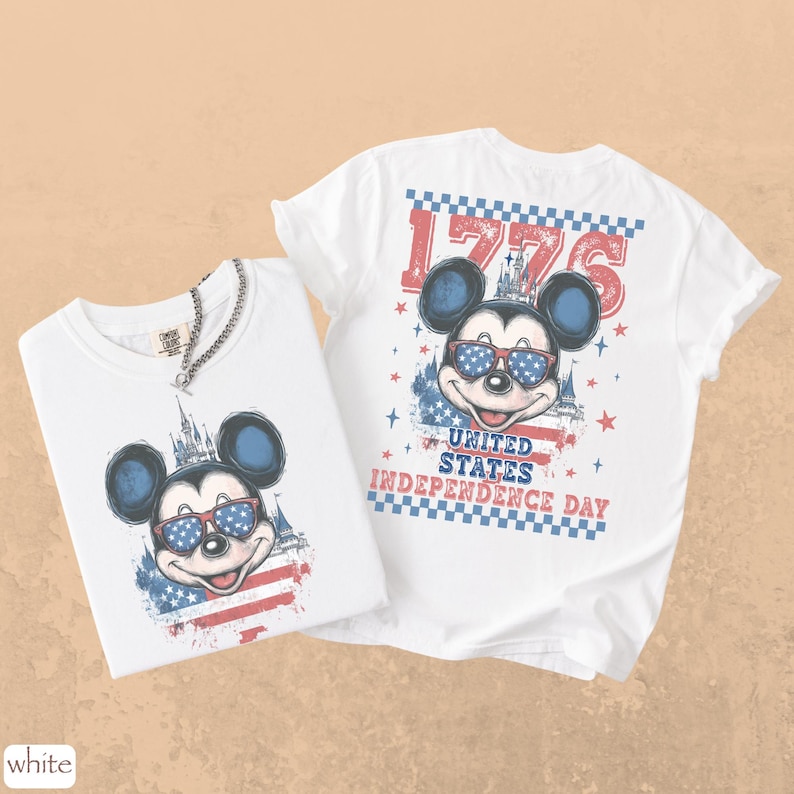 Puede incluir: Dos camisetas blancas con un dise&ntilde;o de Mickey Mouse con gafas de sol de dise&ntilde;o patri&oacute;tico. Una camiseta muestra el dise&ntilde;o en la parte delantera, la otra en la trasera, con el texto "1776" y "United States Independence Day".