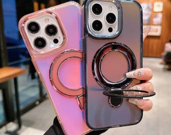 May include: Two iPhone cases with a ring holder. The case on the left is pink and iridescent. The case on the right is black and iridescent.
