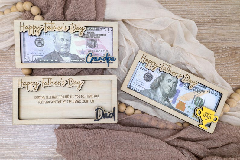 May include: Wooden Father's Day gift boxes with dollar bills inside. The boxes have laser-cut text that says "Happy Father's Day", "Grandpa", and "Dad". One box has a yellow trophy that says "Best Dad".