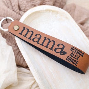 May include: Brown leather keychain with the word "mama" and a heart symbol, followed by the names Jessica, Alex, and Grace.