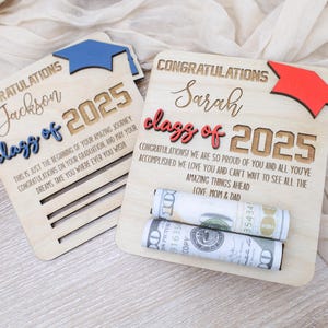 May include: Two wooden graduation signs with the text "Congratulations Jackson Class of 2025" and "Congratulations Sarah Class of 2025". The signs have a graduation cap cutout and are decorated with rolled up cash.