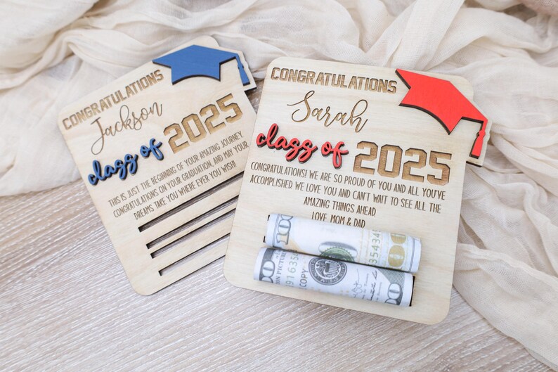 May include: Two wooden graduation signs with the text "Congratulations Jackson Class of 2025" and "Congratulations Sarah Class of 2025". The signs have a graduation cap cutout and are decorated with rolled up cash.