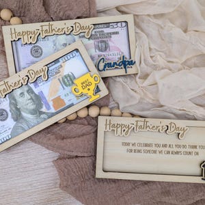 May include: Wooden Father's Day gift boxes with decorative text and dollar bills. One box says "Happy Father's Day" and "Best Dad" with a trophy. Another says "Grandpa". The last box says "Dad".