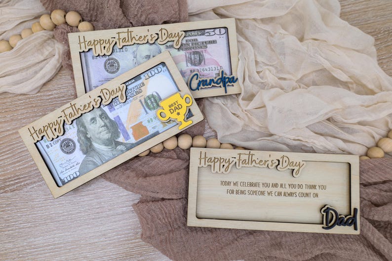 May include: Wooden Father's Day gift boxes with decorative text and dollar bills. One box says "Happy Father's Day" and "Best Dad" with a trophy. Another says "Grandpa". The last box says "Dad".