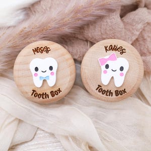 May include: Two wooden tooth boxes with a cute cartoon tooth design. One box is labeled "Moses Tooth Box" and the other is labeled "Katies Tooth Box".