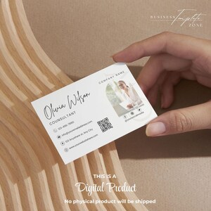 May include: White business card with a minimalist design featuring the name Olivia Wilson, the title Consultant, a phone number, email address, website address, and a QR code. The card also includes a circular photo of a woman in a professional setting.