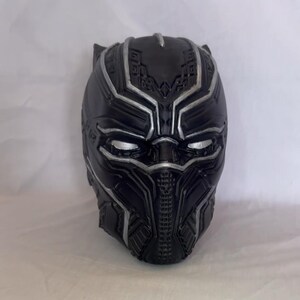 Può includere: Maschera di Black Panther in plastica nera con dettagli argentati. La maschera ha un design dettagliato con una superficie testurizzata.