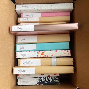 12 Cute wrapped blind date books labeled with each month of the year and genre.