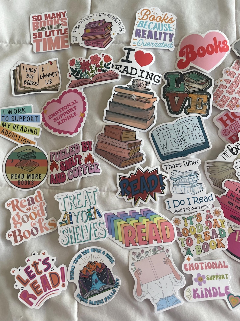 May include: A collection of colorful stickers with book-themed designs and text. The stickers feature phrases like "Read Good Books," "Books Because Reality is Overrated," and "I Love Reading." Various illustrations of books and related imagery are also included.
