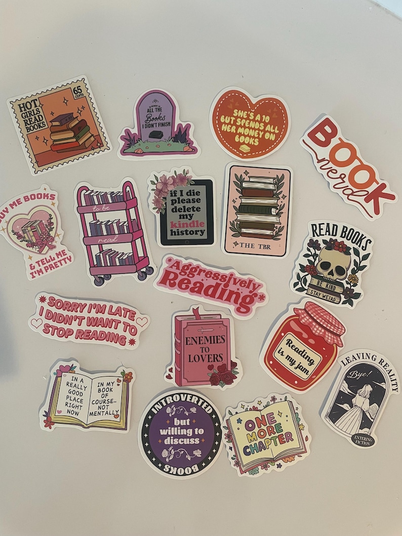 May include: A collection of colorful stickers with book-themed designs. The stickers feature phrases like "Hot Girls Read Books," "Enemies to Lovers," and "One More Chapter." Other designs include stacks of books, a tombstone, and a skull.