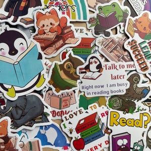 May include: A collection of colorful stickers with a reading theme. The stickers feature various cartoon animals, books, and phrases like "Readers are Leaders" and "I love to read." The stickers are in various shapes and sizes.