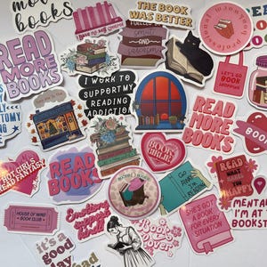 May include: A collection of colorful stickers with book-themed designs and text. The stickers feature phrases like "Read More Books," "Book Lover," and "I Work to Support My Reading Addiction." Various illustrations include stacks of books, a black cat reading, and a bookstore.
