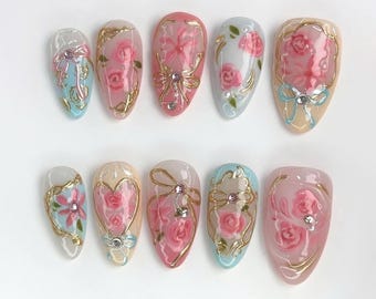 Eleganta rosa press-on naglar med rosenträdgårdsdesign, guldfärgad accent, charmig rosett, vårnagelkonst, perfekt för romantiska, snygga naglar, present