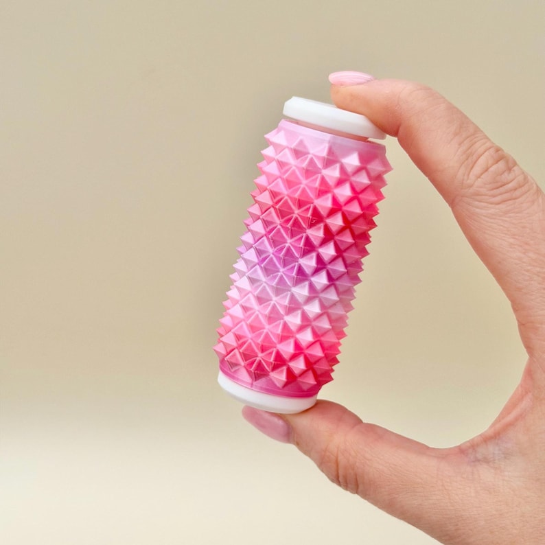 Pink and white spiky sensory roller, rigid stim toy for strong pressure seekers.