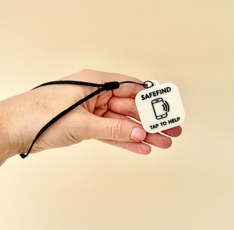 Black NFC tag keyring showing its practical use for quick phone tap access to contact details.