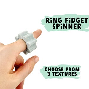 Puede incluir: Un anillo fidget spinner gris con una superficie texturizada. El anillo se lleva en un dedo y gira libremente.  "Ring Fidget Spinner" y "Choose from 3 Textures" están escritos en negro sobre un fondo verde claro.