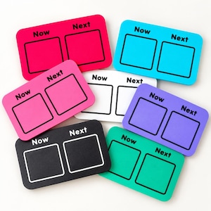 May include: A collection of seven rectangular visual schedule boards in various colours including pink, blue, white, purple, black, and green. Each board features two square outlines with the text Now above the left square and Next above the right.