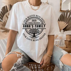 May include: White t-shirt with a black circle design featuring a tree and the text "Our Roots Run Deep 2025 Family Reunion Anna's Family Our Love Runs Deeper".