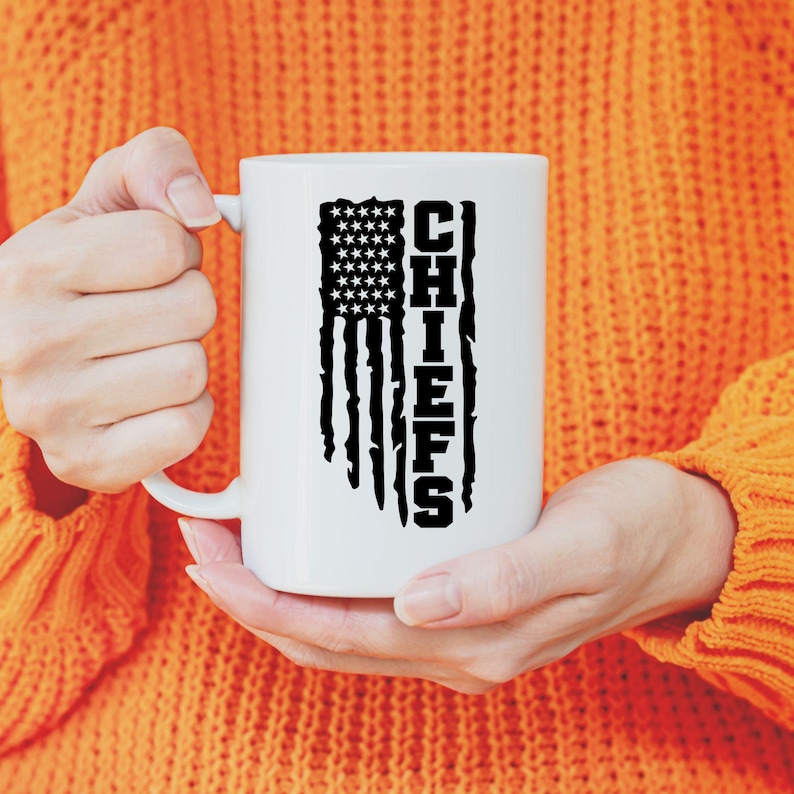 May include: White ceramic mug featuring a black distressed American flag design with the word "CHIEFS" printed vertically on the right side of the flag.