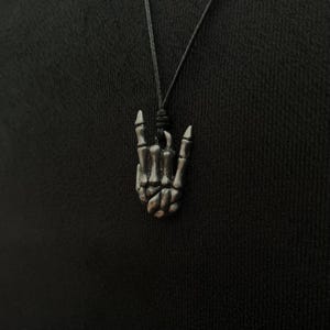 Pingente de mão de esqueleto articulada - Joia gótica ousada para entusiastas de rock, música e arte.