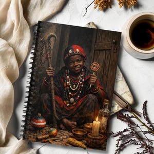 May include: A spiral-bound notebook featuring an illustration of a person wearing a red and black headpiece and layered beaded necklaces, holding a wooden staff and a lollipop, surrounded by a spinning top, a candle, and a glass bottle.