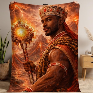 May include: A rectangular throw blanket featuring a vibrant, detailed illustration of a regal figure wearing a golden crown and leopard-print garment. The figure holds a glowing, ornate scepter against a backdrop of erupting volcanoes and lightning.