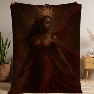 Può includere: Una coperta con un dipinto digitale di una donna in abito rosso e corona d'oro. L'opera d'arte ha un tema regale, con tessuto rosso fluente e una tavolozza di colori scuri e caldi. La donna è il fulcro centrale.
