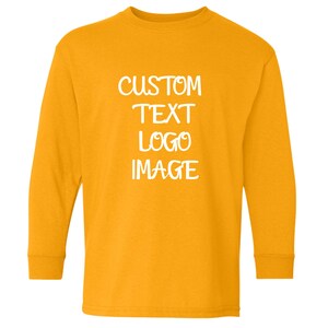 May include: Mustard yellow long-sleeve shirt with the words "CUSTOM TEXT LOGO IMAGE" in white block letters. The shirt has a crew neck and long sleeves. The shirt is made of a soft material.