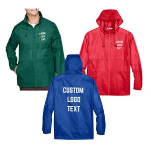 May include: Three custom windbreaker jackets in green, red, and blue. Each jacket has a hood, a zip, and the text "CUSTOM LOGO TEXT" printed on it. The green jacket is being worn by a person.
