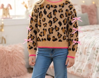 Leopard printed pullover sweater with fuchsia trim and light pink bow on sleeve. TPG60423