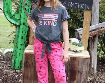 Pantalón de mezclilla bootcut con estampado western en color fucsia.